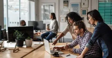 Trois personnes travaillent devant un ordinateur