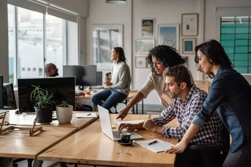 Trois personnes travaillent devant un ordinateur